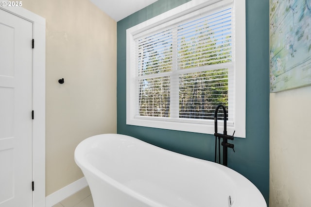 full bath featuring baseboards and a soaking tub