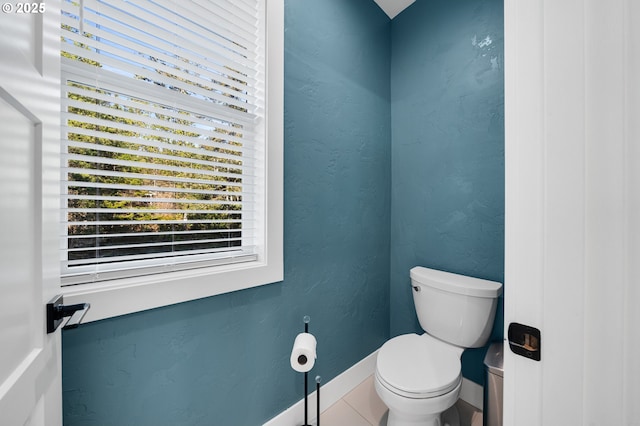 bathroom with baseboards, plenty of natural light, and toilet