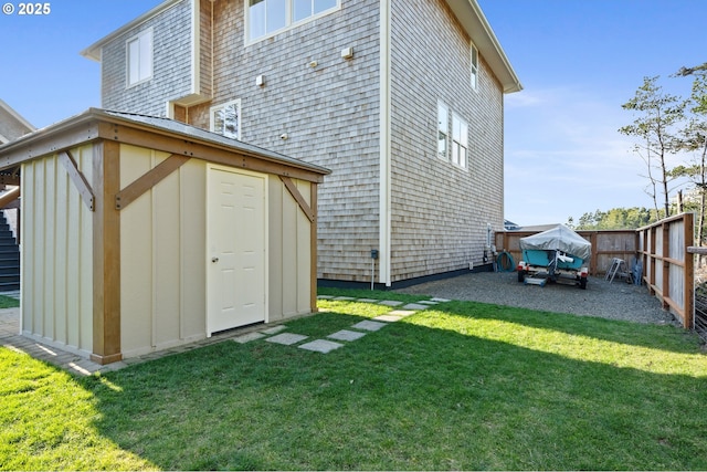 back of house featuring a yard, fence, an outdoor structure, and a shed