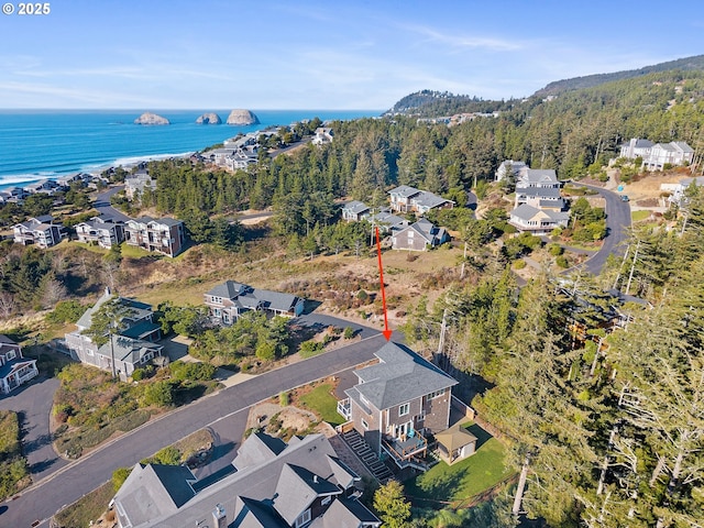 birds eye view of property featuring a residential view, a water view, and a wooded view