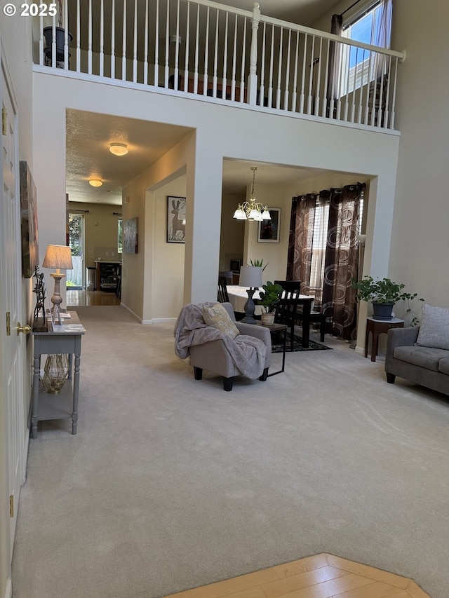 20053 SW 54th Ter, Tualatin, OR 97062 - living room featuring carpet floors, a chandelier, a high ceiling, and baseboards