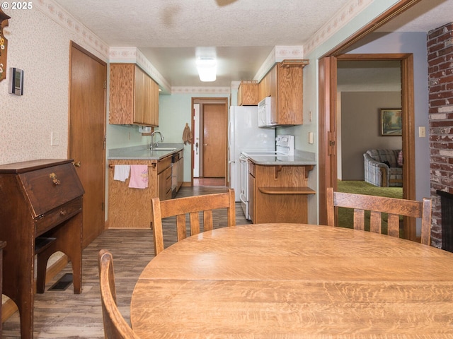 19838 NE Wasco St, Portland, OR 97230 - kitchen featuring wood finished floors, white appliances, light countertops, brown cabinetry, and a textured ceiling