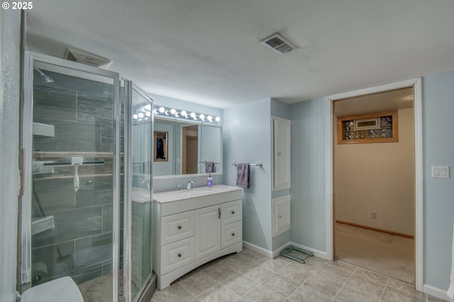 bathroom with a shower with door and vanity