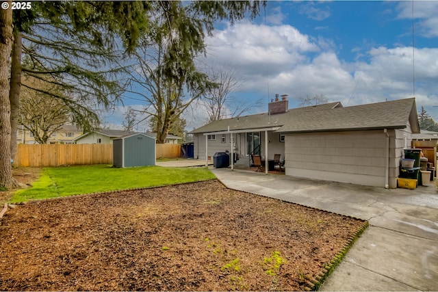 rear view of property featuring a yard, a patio, and a storage unit