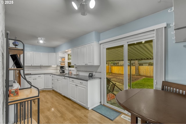 kitchen featuring sink, white cabinetry, white dishwasher, decorative backsplash, and light wood-type flooring