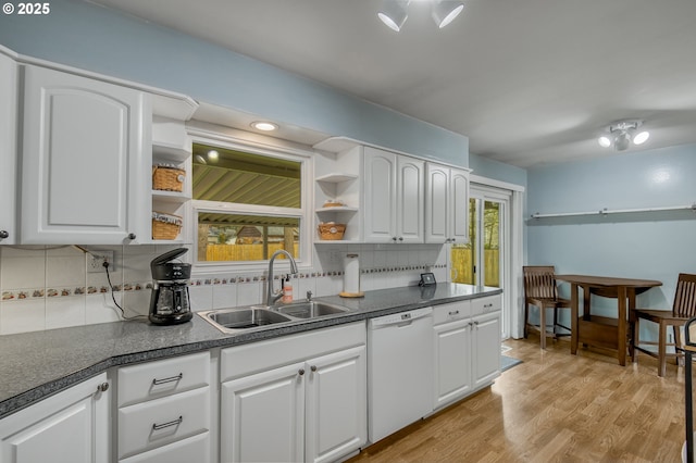 kitchen with tasteful backsplash, white cabinetry, dishwasher, sink, and light wood-type flooring