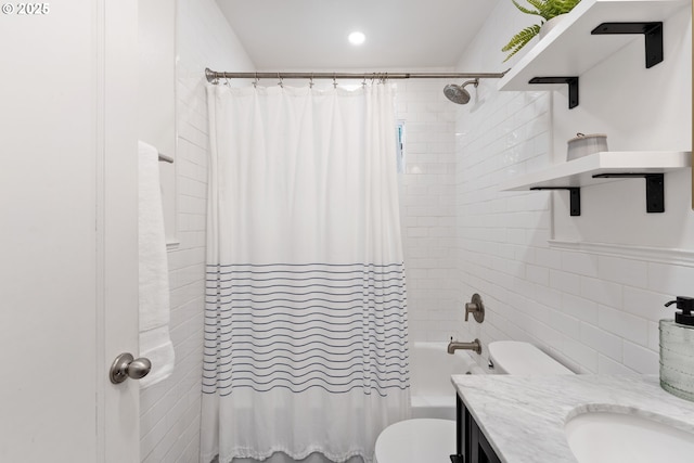 bathroom with vanity, shower / bath combo with shower curtain, toilet, and tile walls
