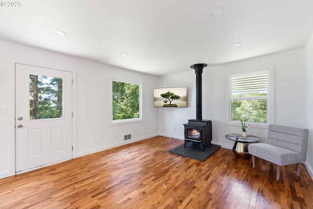 entryway with a wood stove, recessed lighting, baseboards, light wood-type flooring, and visible vents