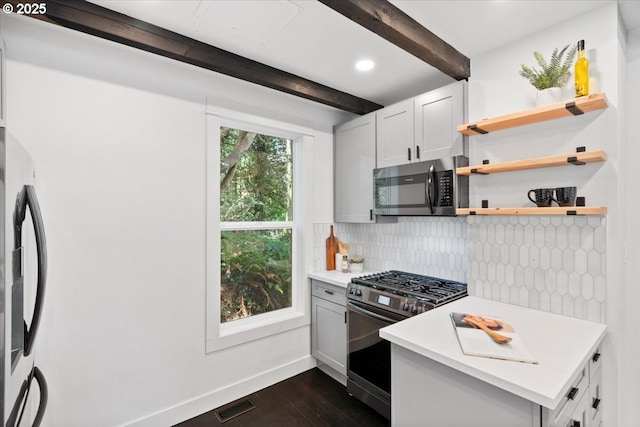 kitchen with white cabinetry, appliances with stainless steel finishes, dark hardwood / wood-style floors, backsplash, and beamed ceiling