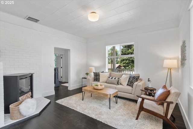 living room with dark wood-type flooring and a fireplace