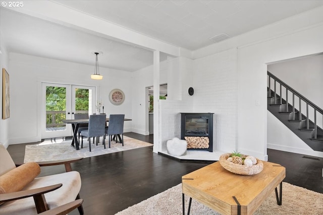 living room with hardwood / wood-style flooring, a fireplace, and french doors