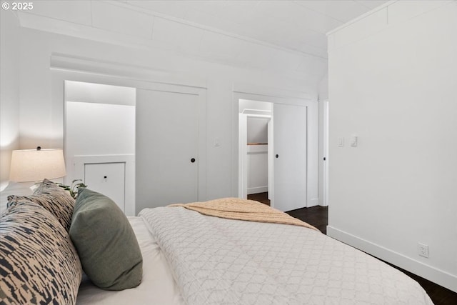 bedroom with dark wood-type flooring and a closet