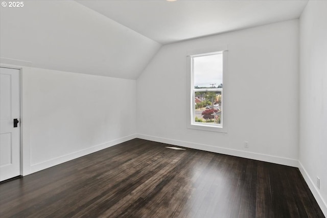 bonus room with dark hardwood / wood-style floors and vaulted ceiling