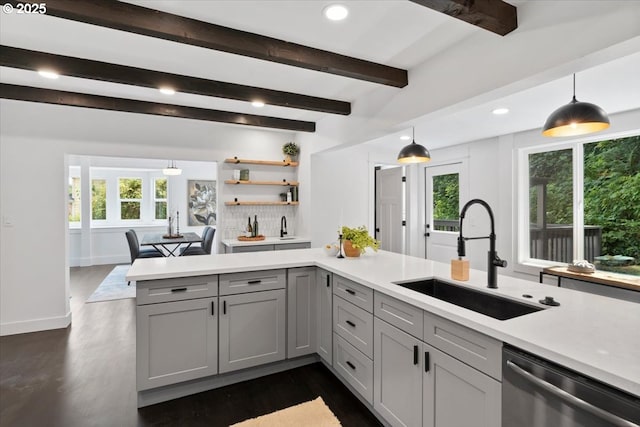 kitchen with pendant lighting, stainless steel dishwasher, kitchen peninsula, sink, and gray cabinetry