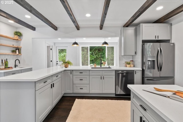 kitchen featuring beamed ceiling, stainless steel appliances, backsplash, and decorative light fixtures