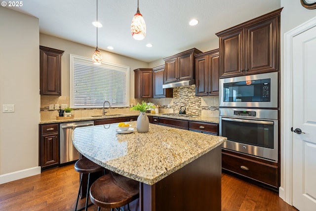 17007 NW Reuben Ln, Portland, OR 97229 - kitchen with appliances with stainless steel finishes, backsplash, dark wood-type flooring, dark brown cabinetry, and recessed lighting