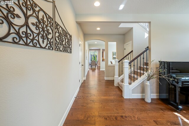17007 NW Reuben Ln, Portland, OR 97229 - corridor with arched walkways, wood finished floors, recessed lighting, and stairs