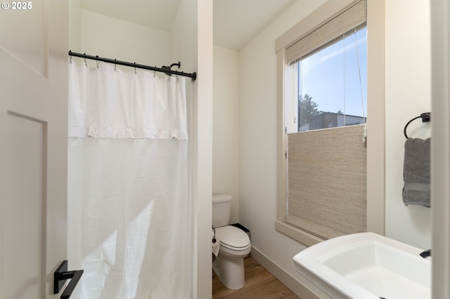 bathroom featuring a shower with shower curtain, toilet, and hardwood / wood-style floors