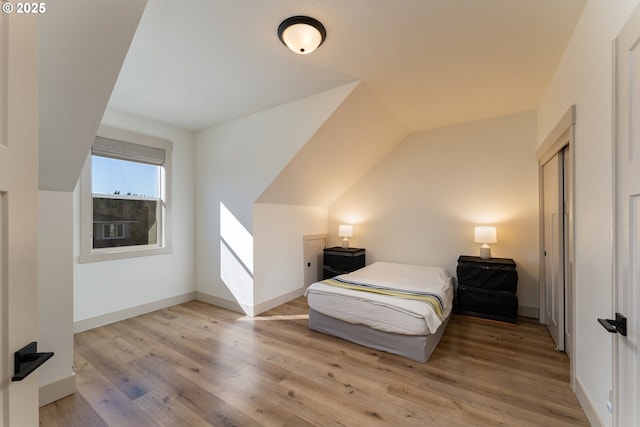 bedroom featuring lofted ceiling and light hardwood / wood-style floors