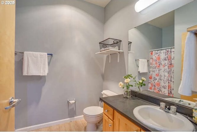 bathroom featuring wood-type flooring, toilet, and vanity