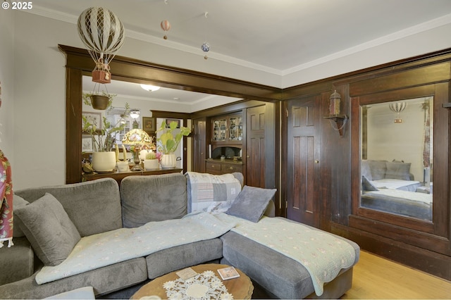 living area featuring ornamental molding and wood finished floors