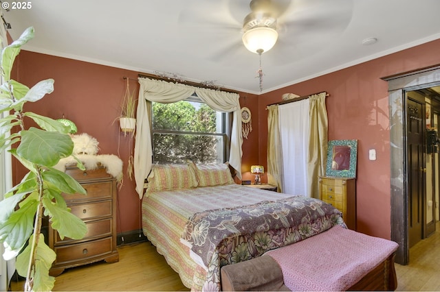 bedroom featuring crown molding, ceiling fan, and wood finished floors