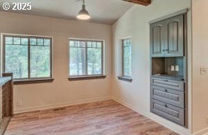 interior space with beam ceiling, baseboards, and wood finished floors