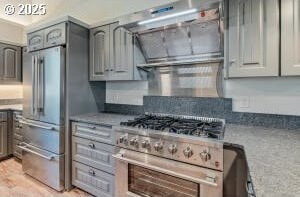 kitchen featuring light wood-style flooring, light stone counters, high end appliances, and gray cabinetry