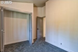 unfurnished bedroom featuring baseboards and dark carpet