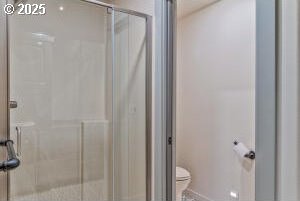 bathroom with a shower stall and toilet