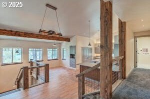 corridor featuring wood finished floors and an upstairs landing