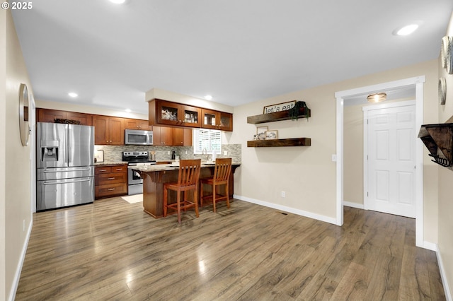 1808 S 4th St, Cottage Grove, OR 97424 - kitchen featuring appliances with stainless steel finishes, wood finished floors, tasteful backsplash, glass insert cabinets, and baseboards