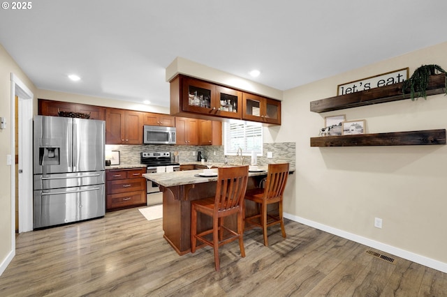 1808 S 4th St, Cottage Grove, OR 97424 - kitchen with stainless steel appliances, light wood finished floors, light countertops, backsplash, and recessed lighting