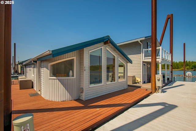 back of property featuring a deck with water view