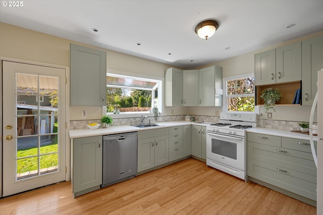 7817 N Washburne Ave, Portland, OR 97217 - kitchen with a sink, light countertops, white gas range oven, light wood finished floors, and dishwasher