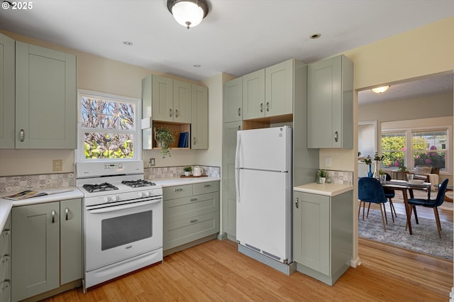 7817 N Washburne Ave, Portland, OR 97217 - kitchen featuring light wood-type flooring, white appliances, and a wealth of natural light