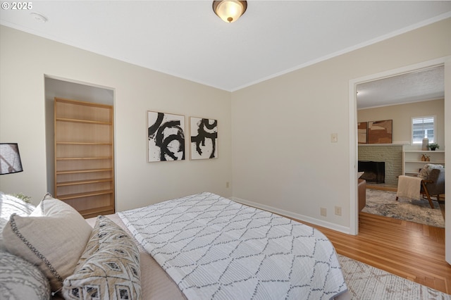 7817 N Washburne Ave, Portland, OR 97217 - bedroom with crown molding, baseboards, a fireplace, and light wood-style floors