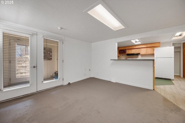 7817 N Washburne Ave, Portland, OR 97217 - unfurnished living room featuring baseboards, concrete floors, and french doors