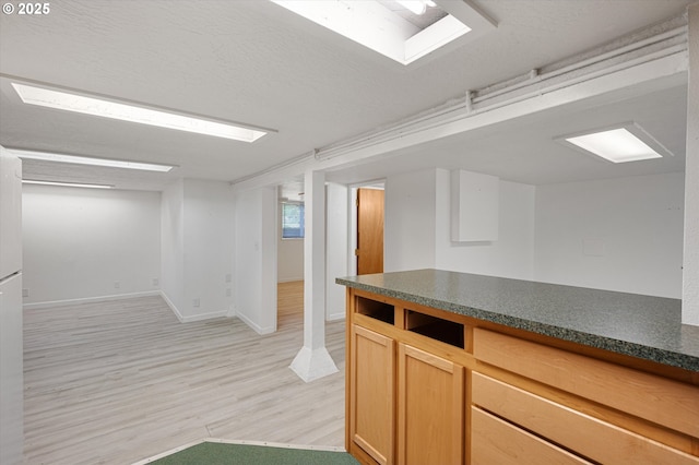 7817 N Washburne Ave, Portland, OR 97217 - kitchen with light wood-style floors, baseboards, and dark countertops