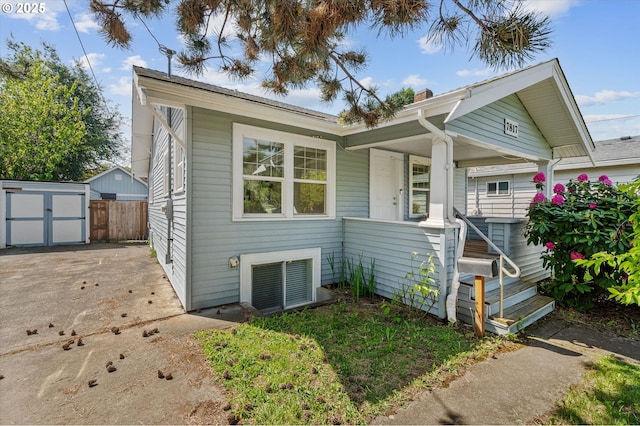 7817 N Washburne Ave, Portland, OR 97217 - bungalow-style house featuring a porch, an outdoor structure, fence, and a storage unit
