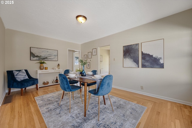 7817 N Washburne Ave, Portland, OR 97217 - dining space with visible vents, light wood-style flooring, and baseboards