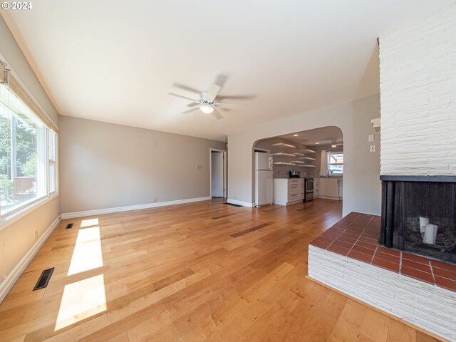 51055109 SE Tibbetts St, Portland, OR 97206 - unfurnished living room featuring arched walkways, a ceiling fan, light wood-style flooring, and baseboards