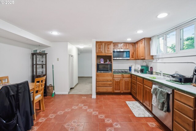 51055109 SE Tibbetts St, Portland, OR 97206 - kitchen with appliances with stainless steel finishes, a sink, washing machine and dryer, tile countertops, and recessed lighting
