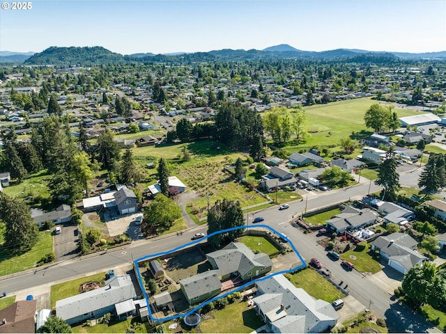 aerial perspective of suburban area with property parcel outlined and a mountainous background