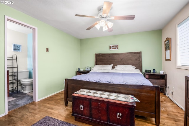 bedroom with wood finished floors, baseboards, a ceiling fan, and ensuite bathroom
