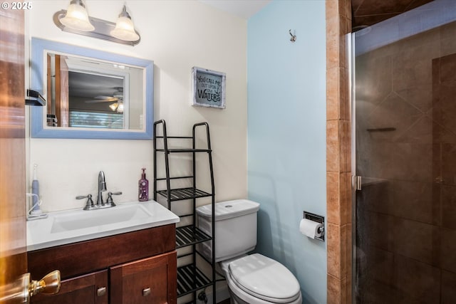 bathroom with a shower stall, toilet, a ceiling fan, and vanity