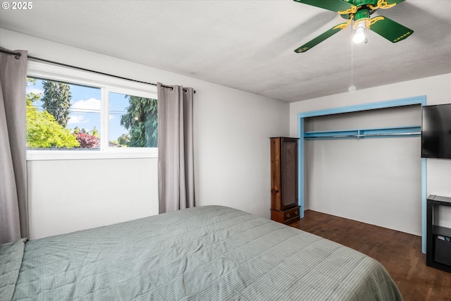 bedroom featuring dark wood finished floors, a ceiling fan, and a closet