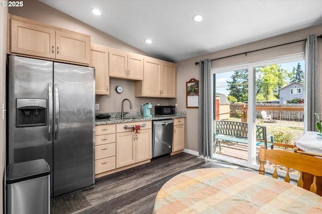 kitchen with stainless steel appliances, light brown cabinets, lofted ceiling, dark wood finished floors, and a sink
