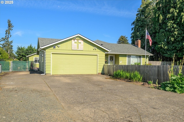 ranch-style home featuring driveway, fence, and an attached garage