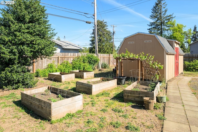 view of yard with a shed, a garden, fence, and an outdoor structure
